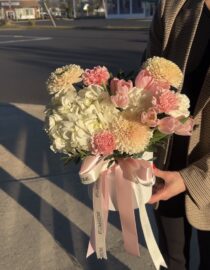 A charming pastel arrangement of pink and white blooms in a chic box with a pink ribbon.