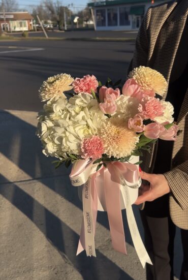 A charming pastel arrangement of pink and white blooms in a chic box with a pink ribbon.