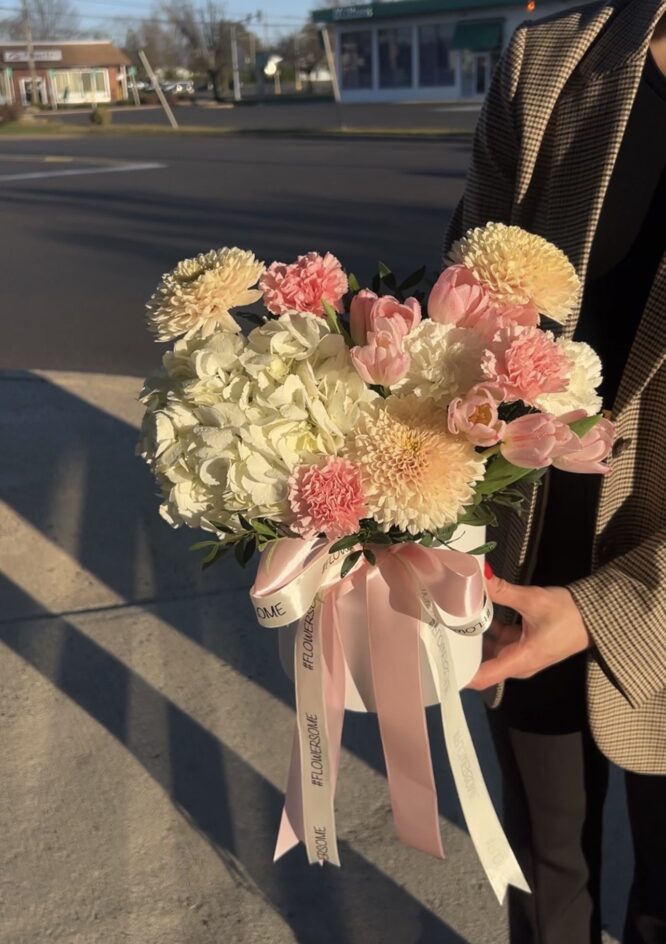 A charming pastel arrangement of pink and white blooms in a chic box with a pink ribbon.